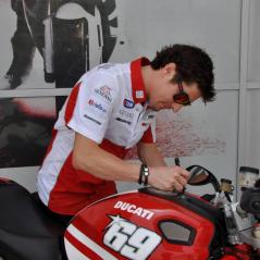 Nicky signs the bike he rode for his grand entrance at the Ducati Caffè grand opening. - Photo: Marcel Bode